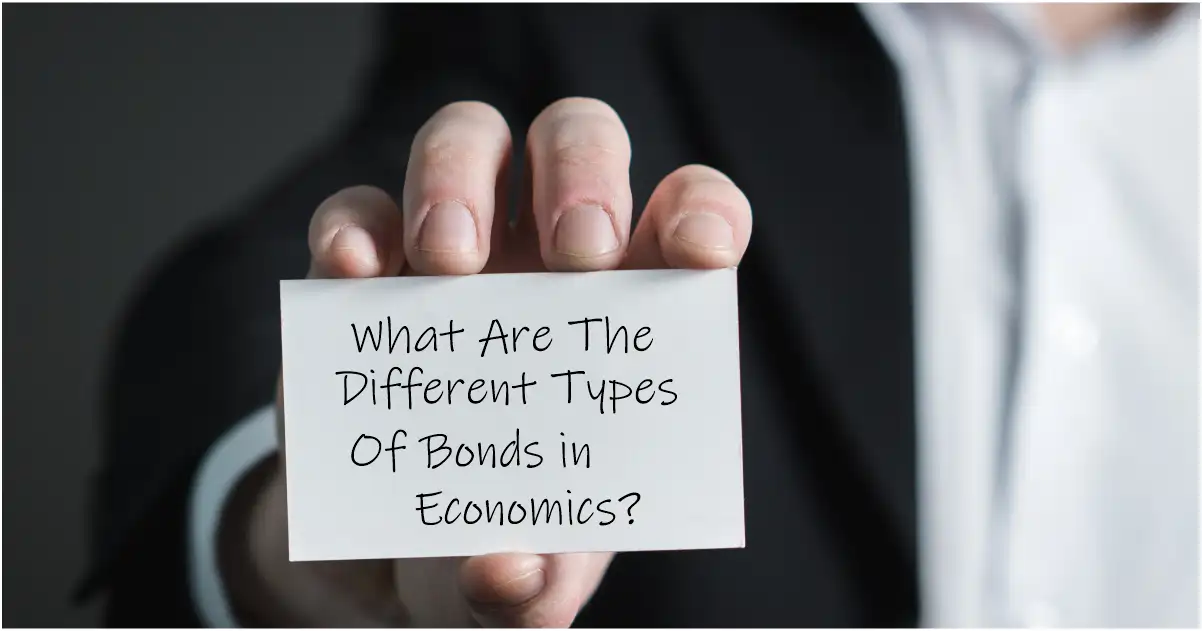A hand holds a hand written card, where it says "What Are The Different Types Of Bonds in Economics?"